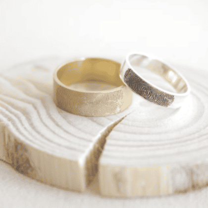Elegant gold and silver custom jewelry rings featuring intricate fingerprint designs, crafted for personalized and unique accessories. Perfect for commemorating special moments or unique style statements.