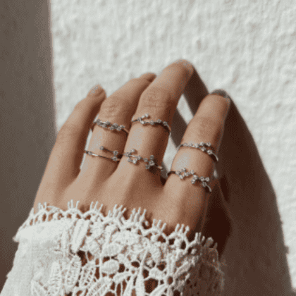 Delicate silver rings with cubic zirconia gemstones, perfect for custom jewelry designs, worn on a woman's hand against a neutral background.