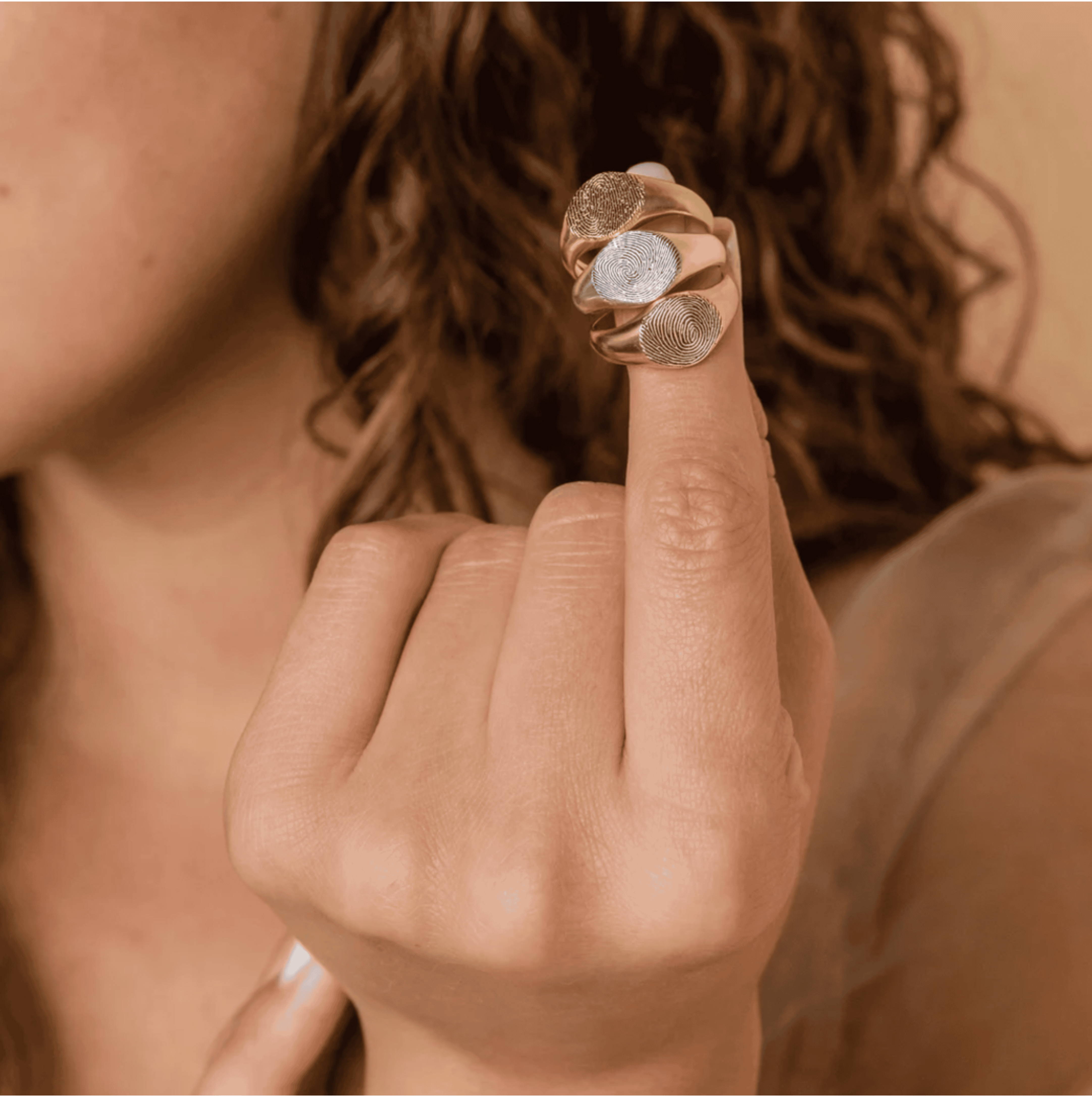 Shiny custom finger rings with fingerprint designs, made of mixed metals, showcased on a woman's hand for jewelry and accessory style.
