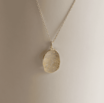 Elegant gold fingerprint engraved pendant necklace, customizable jewelry piece, fine craftsmanship, perfect for personalized jewelry lovers, made by Nayram.