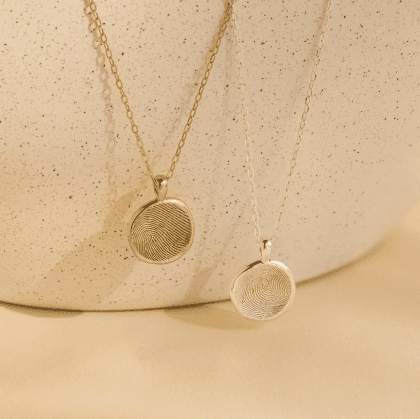 Gold and silver fingerprint jewelry, custom engraved pendant necklaces for men and women, unique personalized jewelry for special occasions.