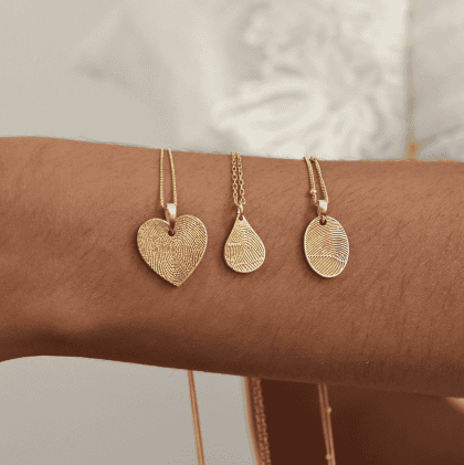 Fine jewelry featuring gold necklaces with unique fingerprint heart, teardrop, and oval pendants, perfect for custom jewelry lovers and personalized gift options.