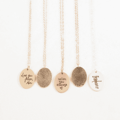 Handmade personalized jewelry with engraved message, fingerprint, and custom designs on delicate gold chains for meaningful gifts.