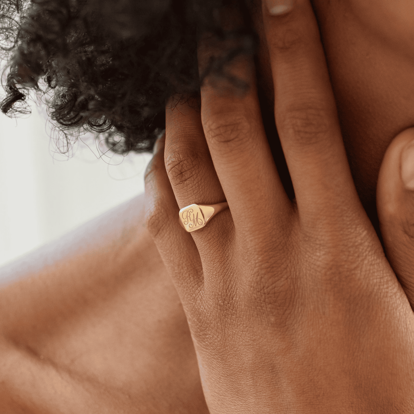 14k gold engraved monogram signet ring on a woman's finger, showcasing custom jewelry craftsmanship.