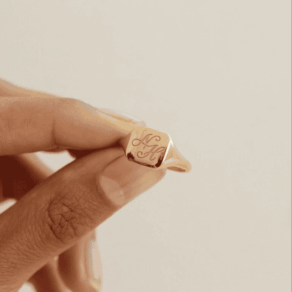 Elegant gold signet ring engraved with initials, perfect for customized jewelry lovers and unique gift ideas.
