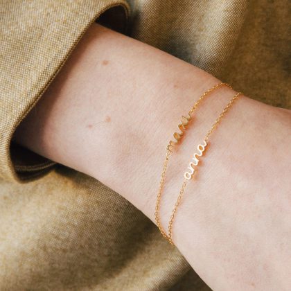 Delicate gold custom name bracelet on wrist, personalized jewelry for women, elegant and minimalist, perfect for everyday wear or special occasions.