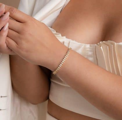 Elegant gold and diamond tennis bracelet on woman's wrist, showcasing exquisite custom jewelry design. Perfect for enhancing your style and adding a touch of luxury.