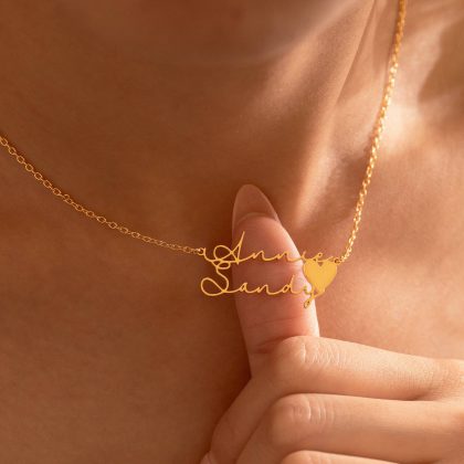 Elegant gold personalized name necklace with a heart charm, perfect for custom jewelry lovers. Handcrafted jewelry piece showcasing intricate design and quality craftsmanship.