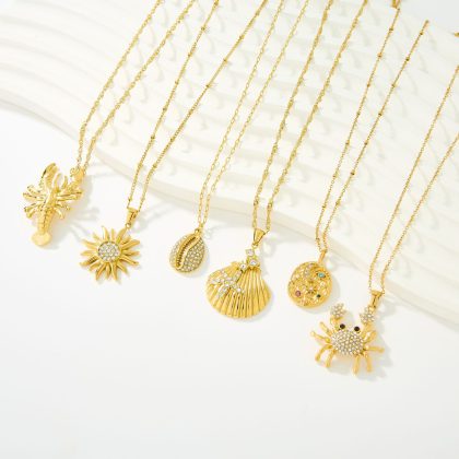 Shiny gold fashion jewelry necklaces featuring various seaside-themed pendant designs including a crab, sun, shell, starfish, conch shell, and round disc with gemstones. Perfect for custom jewelry lovers.