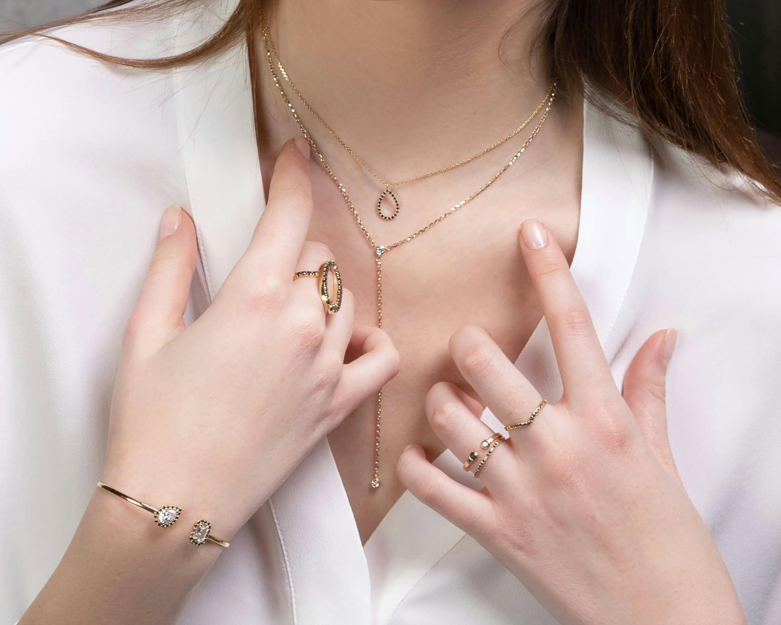 Elegant gold and diamond jewelry set featuring layered necklaces, rings, and a bracelet for women, showcasing custom jewelry design for special occasions.